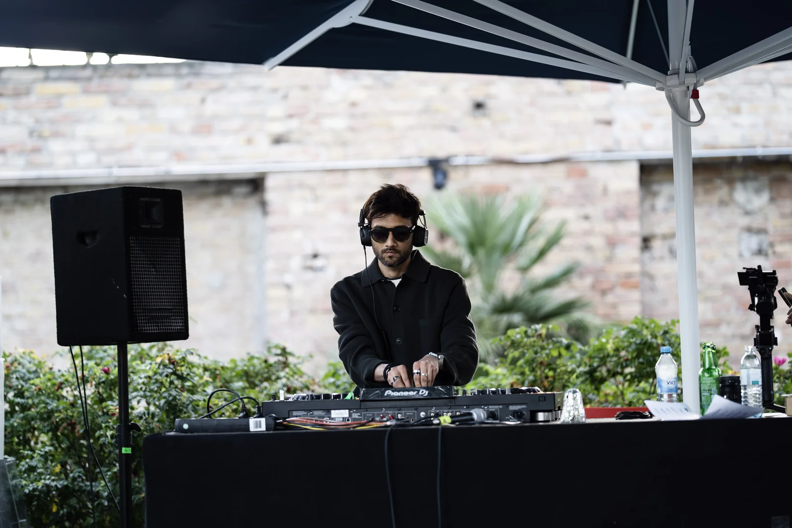Danish wearing headphones and mixing music at outdoor DJ decks.