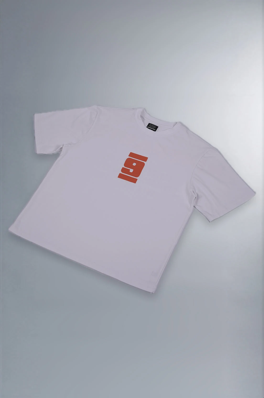 Real flat-lay photograph of the Signature White T-shirt with its orange logo.
